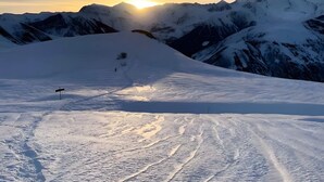 A snow-covered mountain landscape with a clear sky and a sun setting or rising in the background. - Les Balcons de St So Apartment D – Spacious, Sleeps 12, Near Slopes & Shops (Saint-Sorlin-d'Arves)