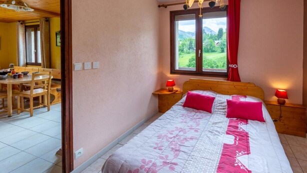 Una camera da letto con un letto, due lampade ai comodini, una finestra vista e una testiera in legno.