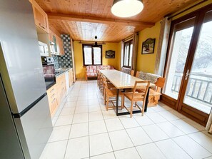 Eine Küche mit Essbereich, Holzboden und großen Fenstern.