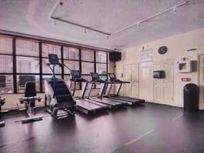 A gym with treadmills, a stationary bike, and a punching bag. - Cozy 1-bedroom 1.5 bath condo with AC in charming Hallandale Beach. Pool + gym. (Hallandale Beach)