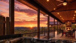 Un área de hidromasaje con terraza de madera, un brasero y vistas al atardecer.