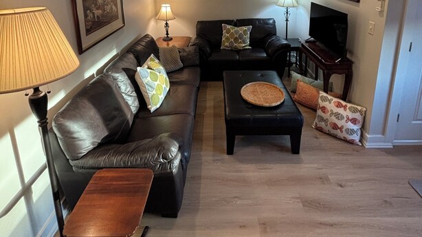 En stue med sofa, sofabord, lampe og fjernsyn.