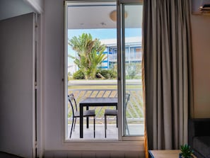 A room with a sliding glass door leading to an outdoor area with a table and chairs.
