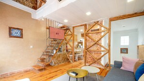 Un interior moderno con una escalera, un sofá, una mesa de centro y una zona de cocina.
