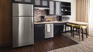 A modern kitchen with a stainless steel refrigerator, a microwave, and a coffee maker. - Accessible Studio Suite w/ Tub + Free Breakfast! (Seattle)
