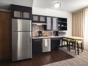 A modern kitchen with a stainless steel refrigerator, a microwave, and a coffee maker.