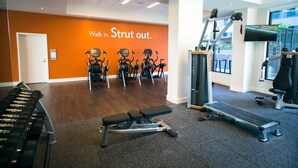 A gym with treadmills, a bench, and a wall with motivational text.