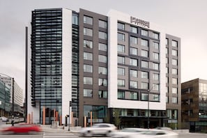 Een modern hotel met een opvallende verticale gevel en een vlakke voorgevel.