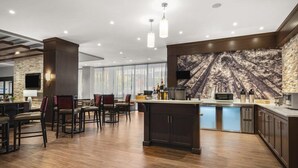 Una cocina moderna con una pared de acento de piedra, asientos de bar y una isla grande.