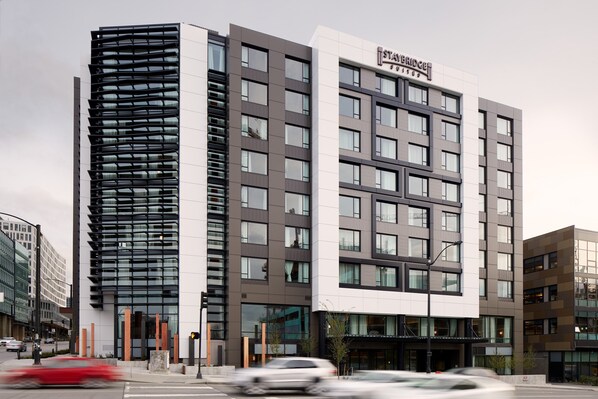 Un hotel moderno con una sección vertical destacada y una fachada plana.