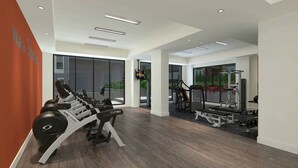 Une salle de sport moderne équipée de machines de cardio, d’appareils de musculation et de grandes fenêtres offrant une vue sur l’extérieur.