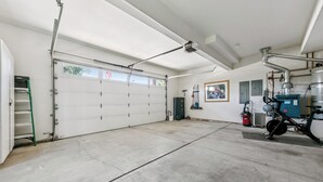 Un garage con pavimento in cemento, porta chiusa e una bicicletta.
