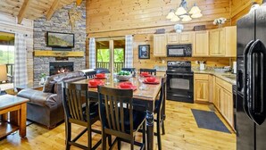 Ein Holzblockhaus-Interieur mit Essbereich, Küche und Kamin.
