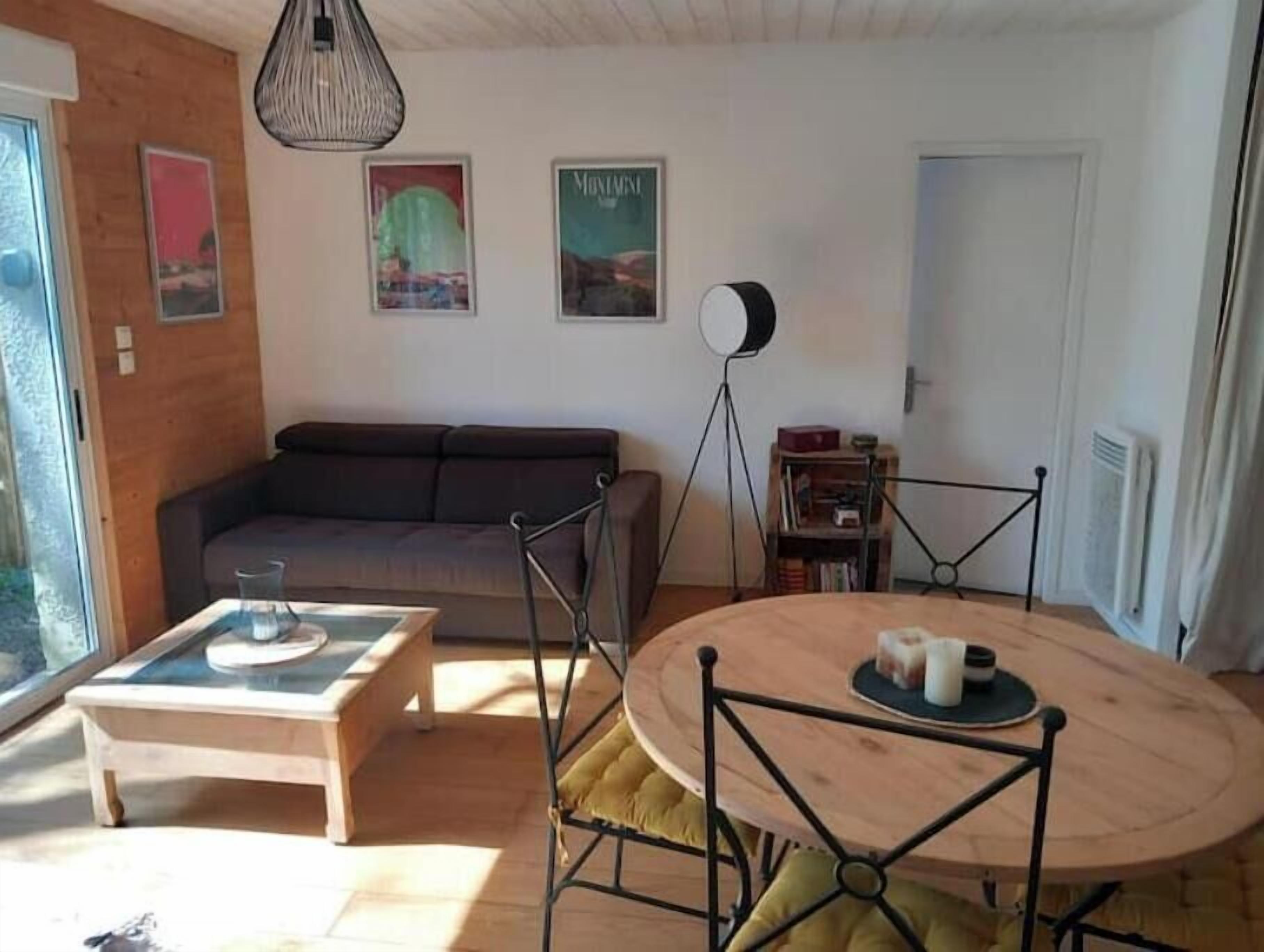 Un salon comprenant un canapé, une table basse, une table à manger avec des chaises, un lampadaire et une bibliothèque.