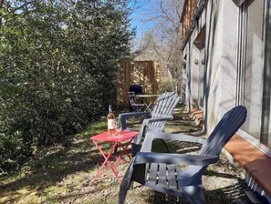 A patio with outdoor furniture, a table, and a bottle of wine. - Alzeau Socket Housing (Lacombe)