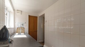 Una cocina con encimera de granito, electrodomésticos blancos y puerta de madera.