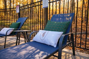 Two sun loungers with cushions, a metal fence, and a sign in the background. - Hocking Hills, Pool, Hottub & Sauna (Logan)