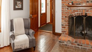 A room with a fireplace, a door leading to another room, and a framed picture on the wall.