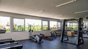 Ett gym med löpband, en crosstrainer och en ställning för knäböj.