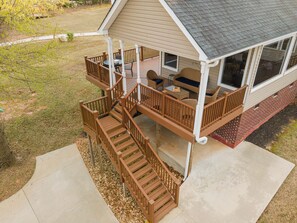 Eine zweistöckige Terrasse mit Gartenmöbeln und einem überdachten Bereich.