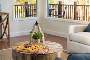 Et rundt træbord med en bakke snacks og en lille plante i en flettet kurv.
