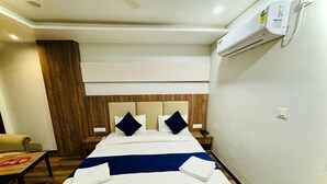 Camera d'albergo con un letto, comodini, un climatizzatore e una parete rivestita in legno.