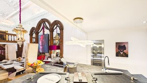 Una cucina moderna con un piano di lavoro in marmo, un lavello incassato e una zona pranzo con un tavolo apparecchiato per due.