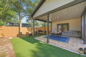 A covered patio area with a barbecue grill, outdoor furniture, and a cushioned seating area. - Country Retreat home with Private pool,Near Orlando International Airport (Kissimmee)