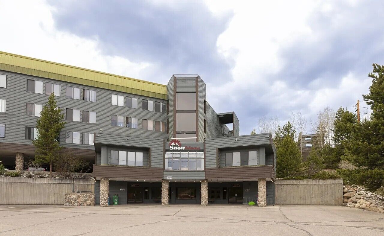 A multi-story hotel with a prominent 'Snowflake' sign, featuring a modern architectural design with a mix of flat and sloped roofs, and a central vertical element.