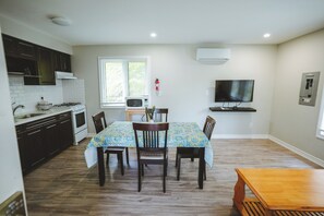 A modern kitchen with dark cabinets, a white countertop, and a built-in oven. - Finch Cottage - 2-Bedrooms - Family Friendly (Trent Lakes)
