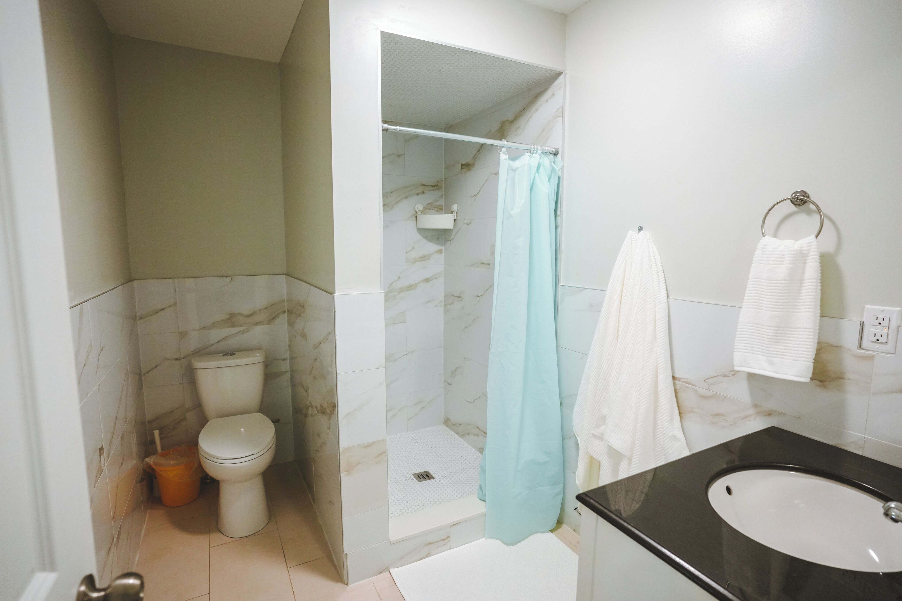 Un baño con inodoro, ducha y lavamanos.