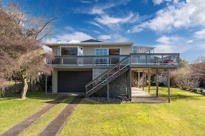 A two-story house with a garage, a covered outdoor area, and a staircase leading to the upper level. - JOE'S Getaway - Omori Holiday Home (Omori)