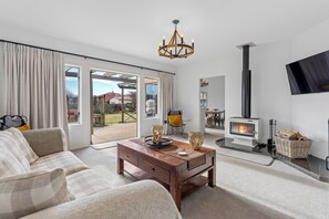 Ein geräumiges Wohnzimmer mit einer Couch, einem Couchtisch aus Holz und einem Kamin.