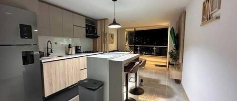 Cafetera o tetera, microondas, horno y placa de cocina