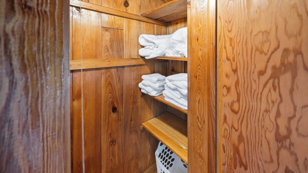 A wooden interior with shelves holding folded towels. - Bayou Bungalow - Walk to Downtown Tarpon Springs (Tarpon Springs)