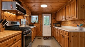 A compact kitchen with wooden cabinets, a built-in microwave, and a stove.
