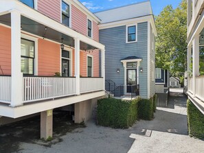 A residential building with a covered porch, a small front yard, and a pathway leading to the entrance. - Brand New - Downtown 2 Bedroom (Charleston)