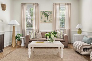 A cozy living room with a sofa, a coffee table, and a bookshelf. - Brand New - Downtown 2 Bedroom (Charleston)