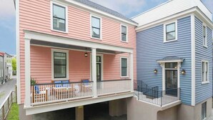 A two-story residential building with a covered porch and a small balcony. - Brand New - Downtown 2 Bedroom (Charleston)