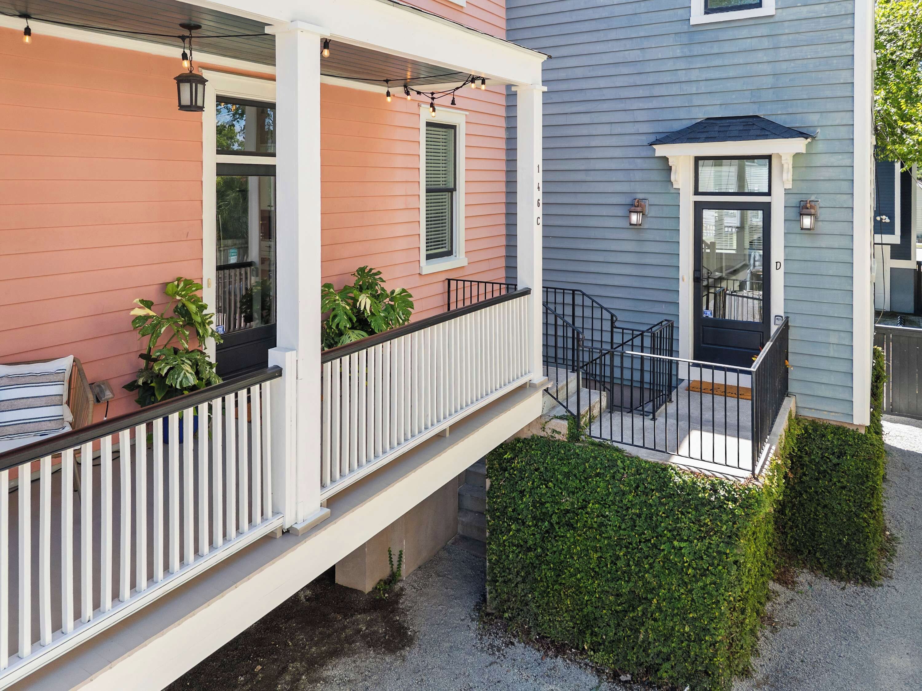 A two-story house with a covered porch, a front door, and a small front yard.