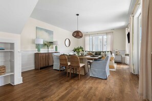 Un salón amplio con una mesa de comedor, sillas y un sofá.