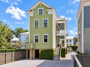 A two-story residential building with a front porch and a balcony.