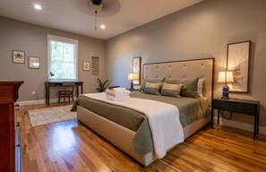 Ein Schlafzimmer mit einem großen Bett, einem Schreibtisch und einem Stuhl.