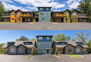 Eine Reihe moderner zweistöckiger Häuser mit einem zentralen, blauen Gebäude, jedes Haus mit einer Garage und einem Vorgarten.