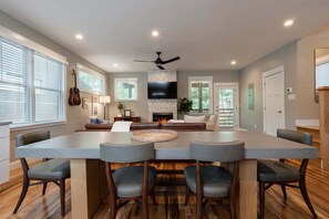 A spacious living area with a large central island, seating, a fireplace, and a television. - The Fold at Reynolds Mountain | Asheville 10 Townhomes, Hot Tubs, Sleeps 80 (Asheville)