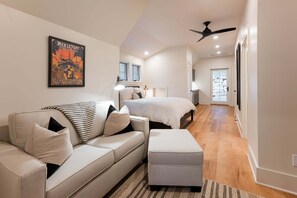 Une chambre à coucher moderne avec un lit, un canapé et un ventilateur de plafond.