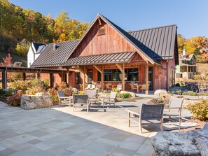 Un bâtiment rustique en bois doté d’un patio couvert aménagé avec des meubles d’extérieur.