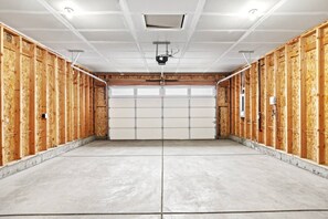 Eine Garage mit Holzwänden, einem Betonboden und einer weißen Garagentür.