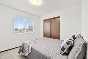 A bedroom with a bed, a window, a closet, and a view of the outside. - Cheney Home | Close to Interstate & Airport (Cheney)
