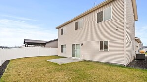 A two-story building with a fenced backyard, a covered patio, and a small garden area. - Cheney Home | Close to Interstate & Airport (Cheney)